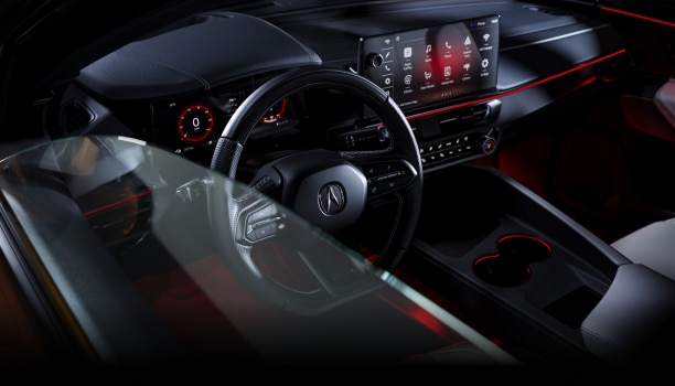 Gros plan de trois quarts en plongée du volant et de l’habitacle, vu à travers la vitre du conducteur.