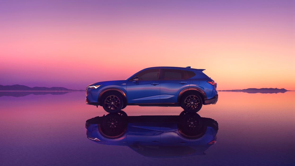 Acura ADX vu de côté devant un coucher de soleil rose.