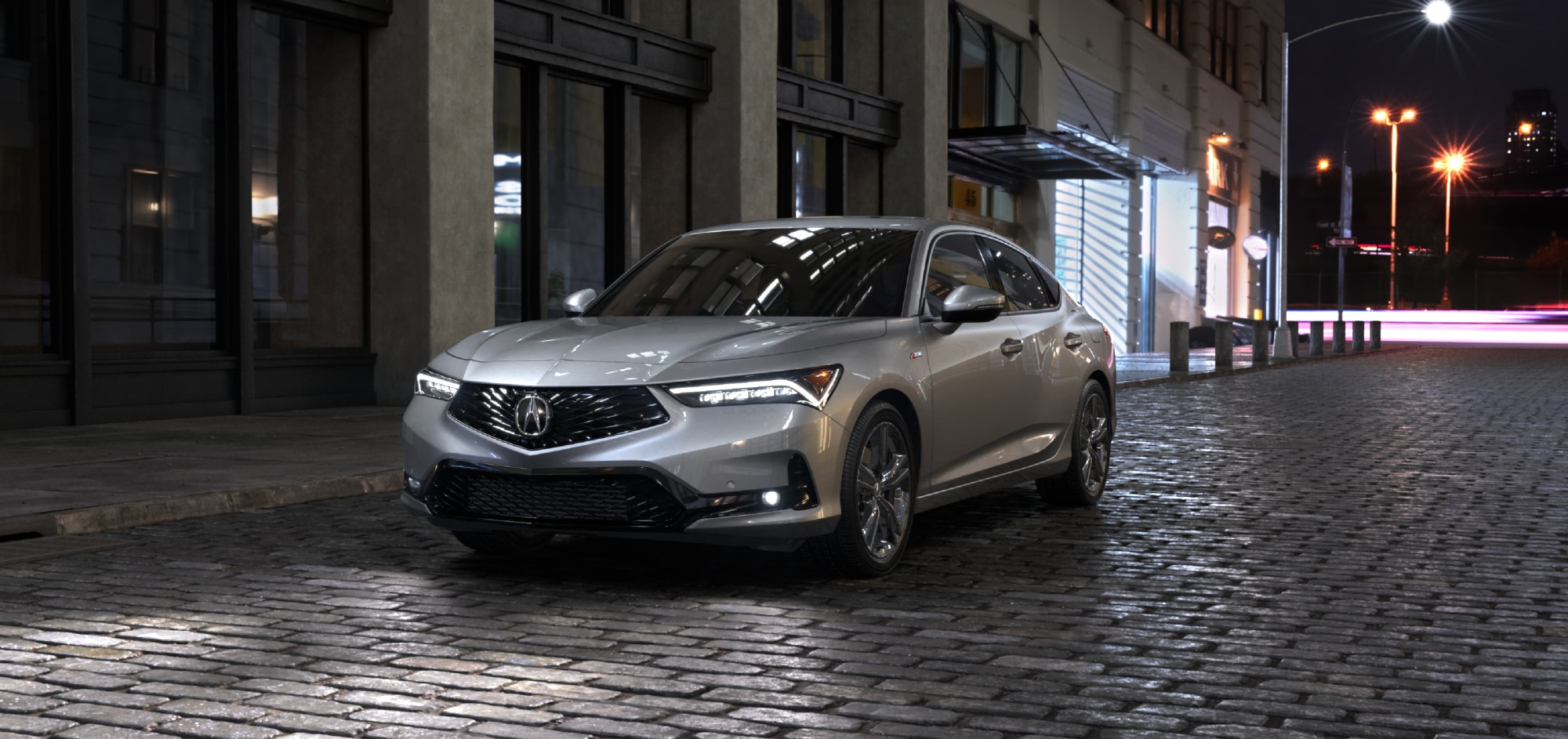 Vue 3/4 avant côté conducteur du MDX bleu 2025 stationné à l'extérieur d'un bâtiment moderne avec vue sur l'océan