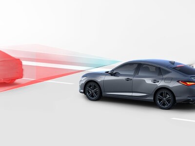 Représentation numérique, où tout est blanc sauf l’Integra. Plan de trois quarts latéral arrière d’une Integra grise roulant sur une route. Des lignes bleues et rouges jaillissent de l’avant de l’Integra pour détecter le véhicule qui précède.