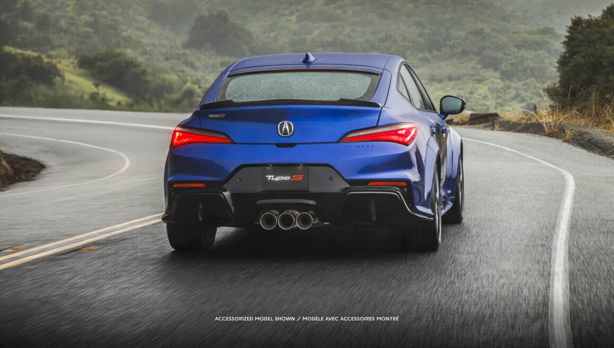 Vue arrière d’une Integra bleue roulant sur une autoroute. 