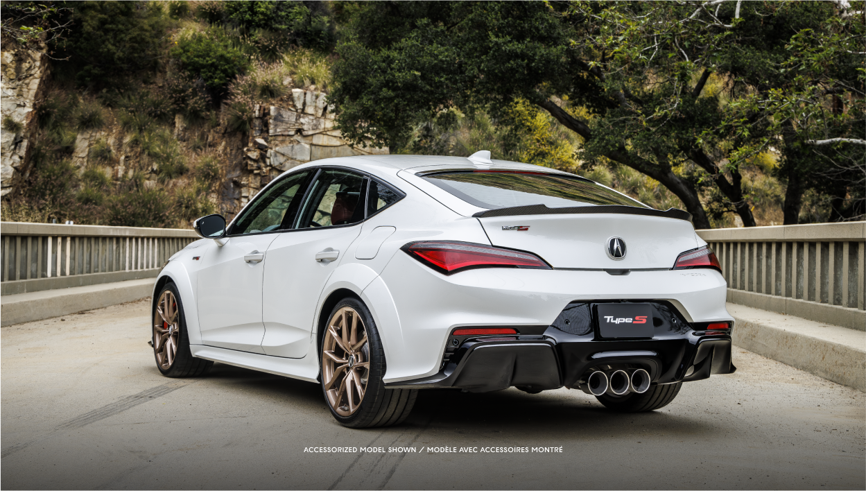Rear-view of white Integra driving on an open road.