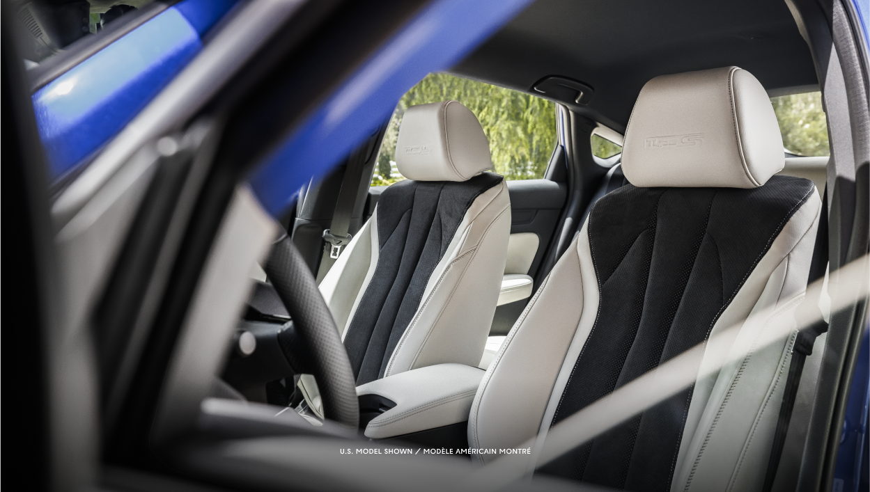 Medium side-view of the driver and passenger seats through an open door.