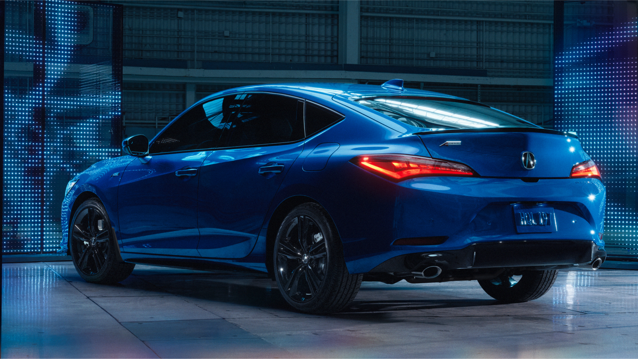 Gros plan de la calandre avant sans cadre de l’Integra 2023 avec emblème Acura illuminé sur fond sombre