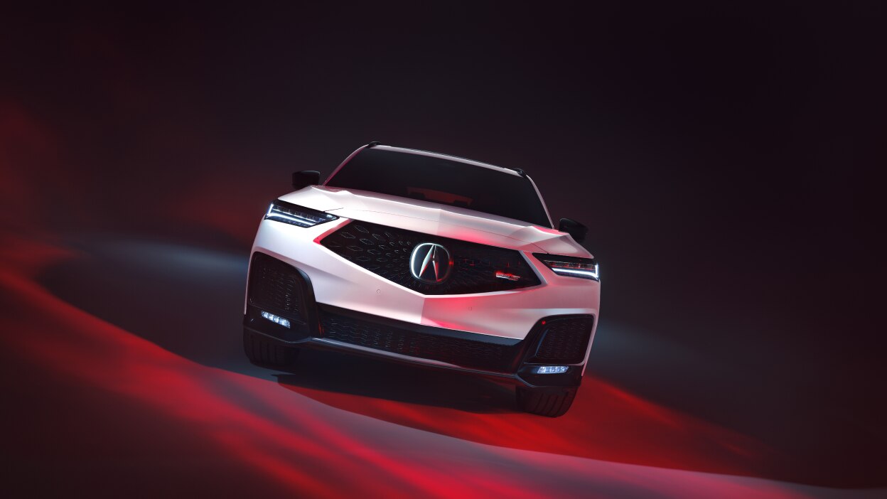 A grey MDX driving down a snowy road in the wilderness.