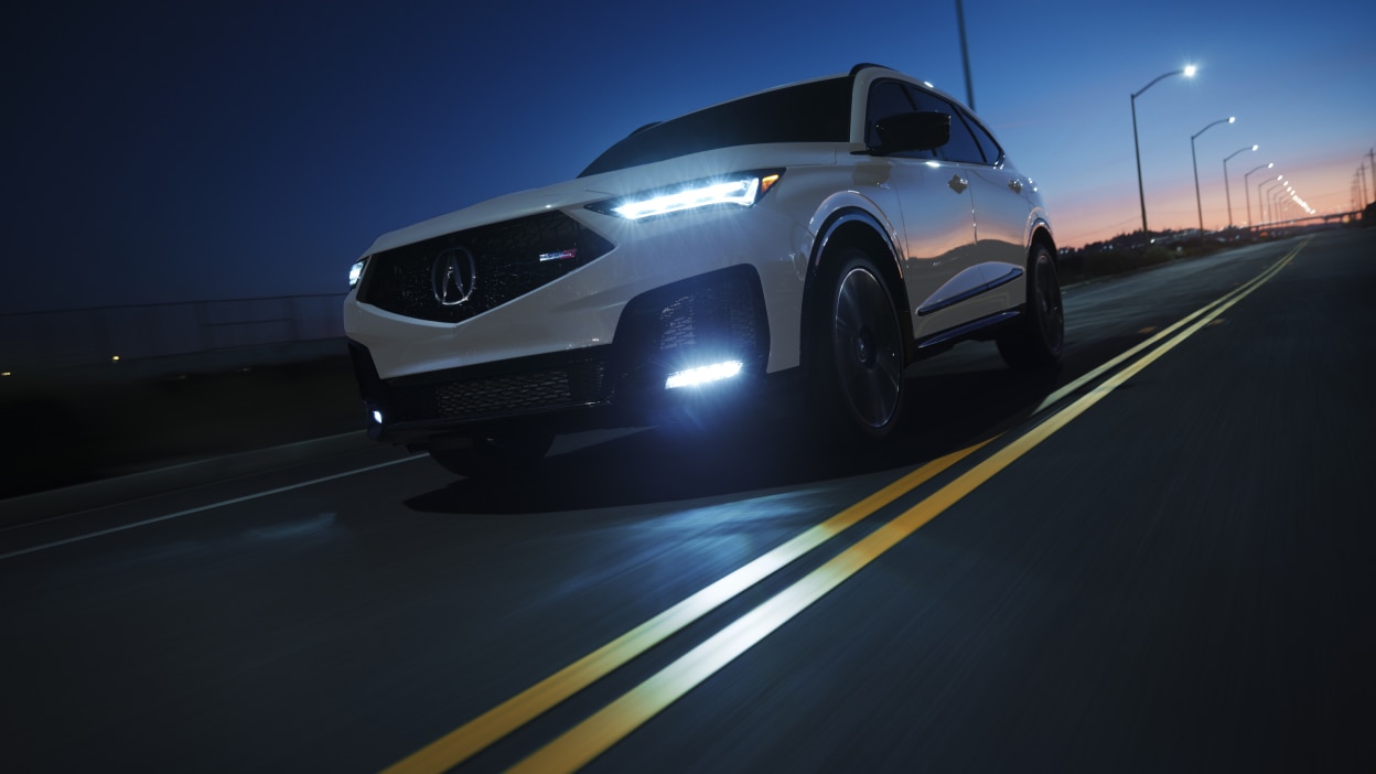 MDX rouge qui prend un virage en pleine nature.