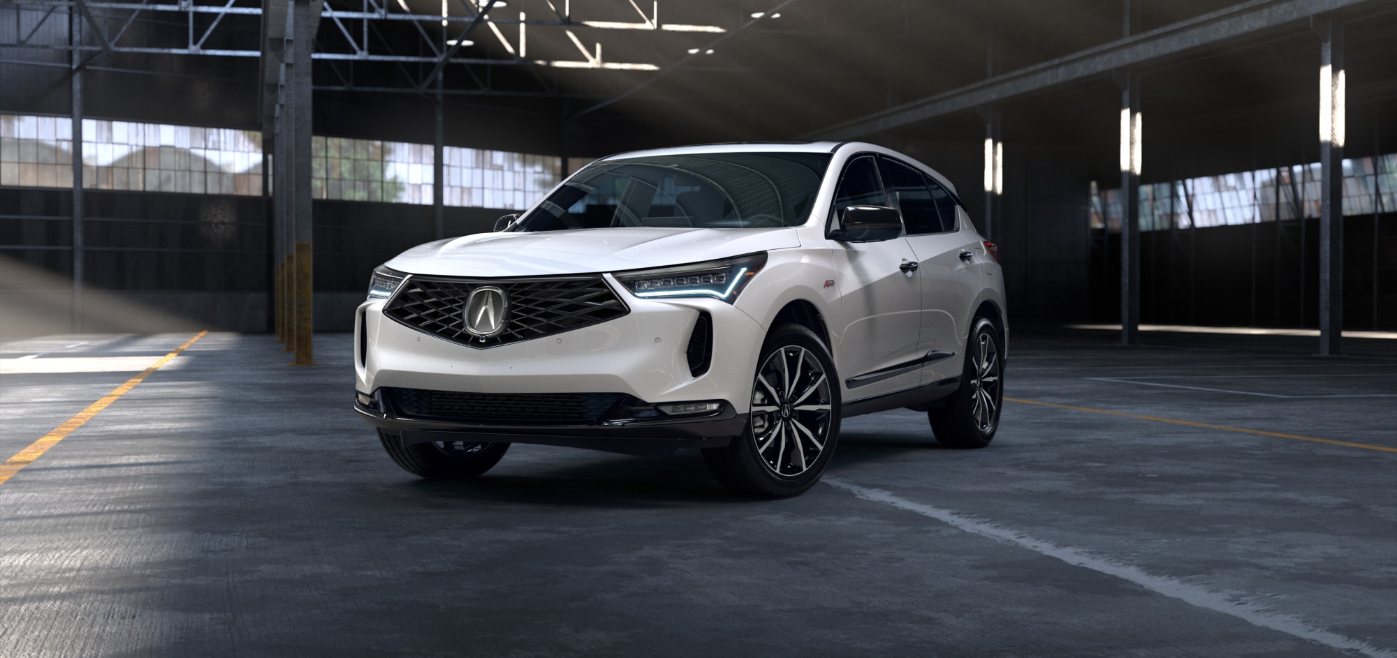 Vue de profil côté conducteur d'un modèle RDX 2025 blanc stationné à l'intérieur d'un entrepôt vide.