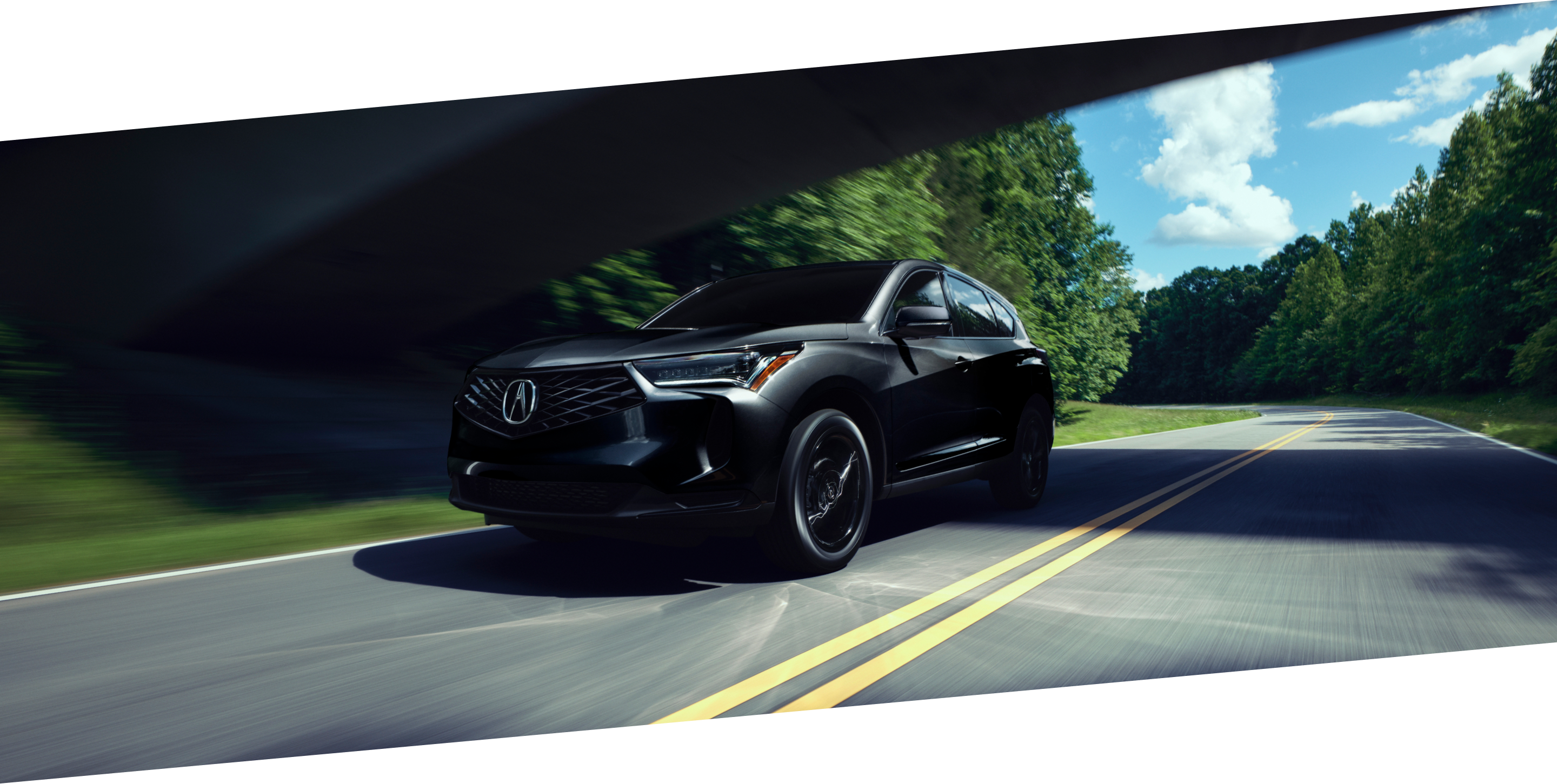 3/4 front side view of black RDX driving on countryside highway during the day.