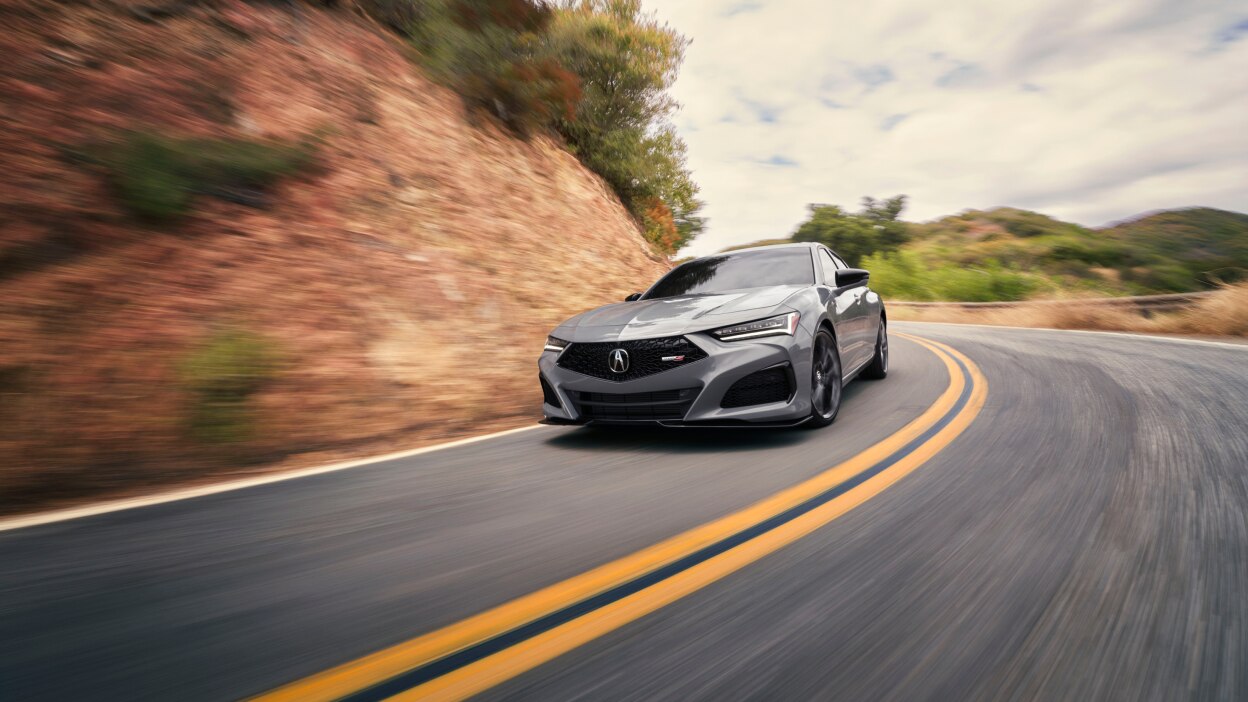 Vue arrière d’une TLX blanche circulant sur un pont.