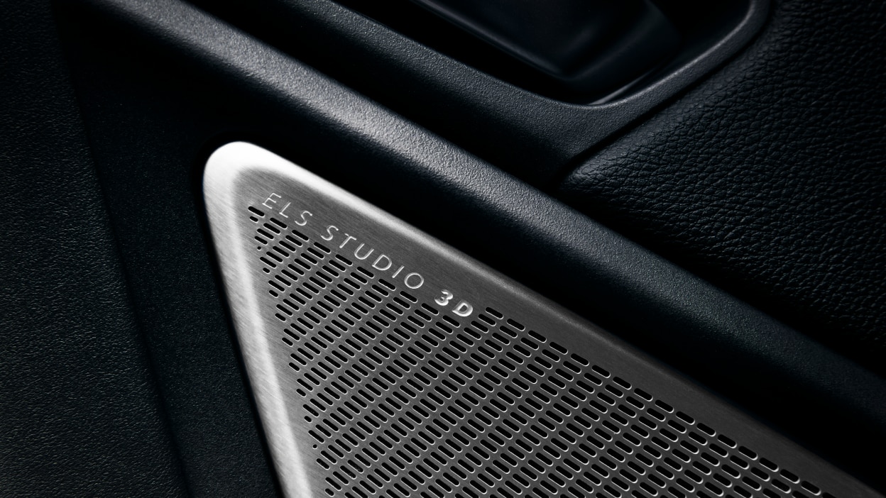 A hand pulls a paddle shifter behind the steering wheel.