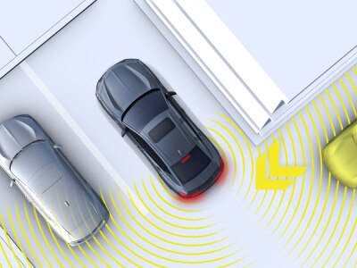 Représentation numérique, où tout est blanc sauf la TLX. Plan en plongée d’une TLX grise qui sort d’une place de stationnement en marche arrière. Lignes jaunes projetées depuis l’arrière qui détectent un véhicule en périphérie.