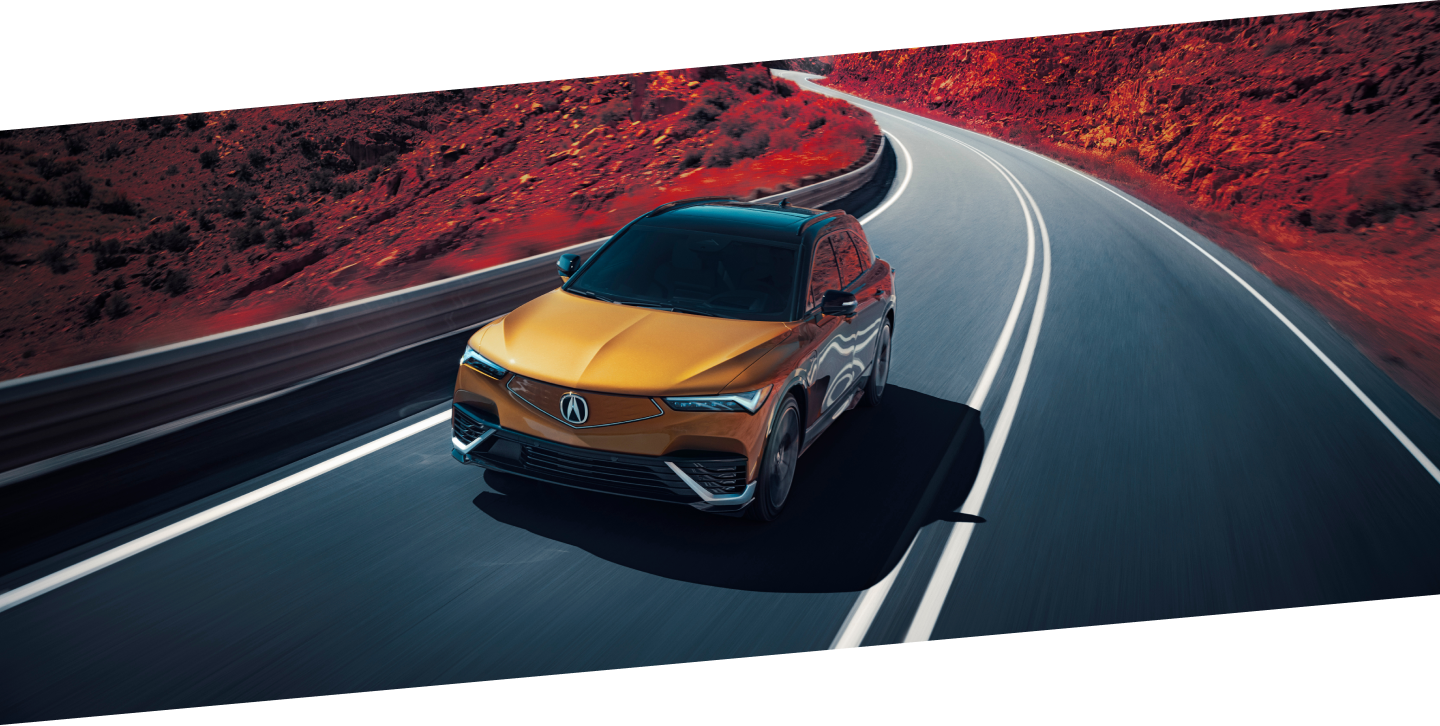 Plan de trois quarts avant en plongée d’un ZDX or roulant sur une autoroute de montagne. Une partie de l’image est saturée de couleur, de sorte que la poussière sur les côtés de l’autoroute est rouge.