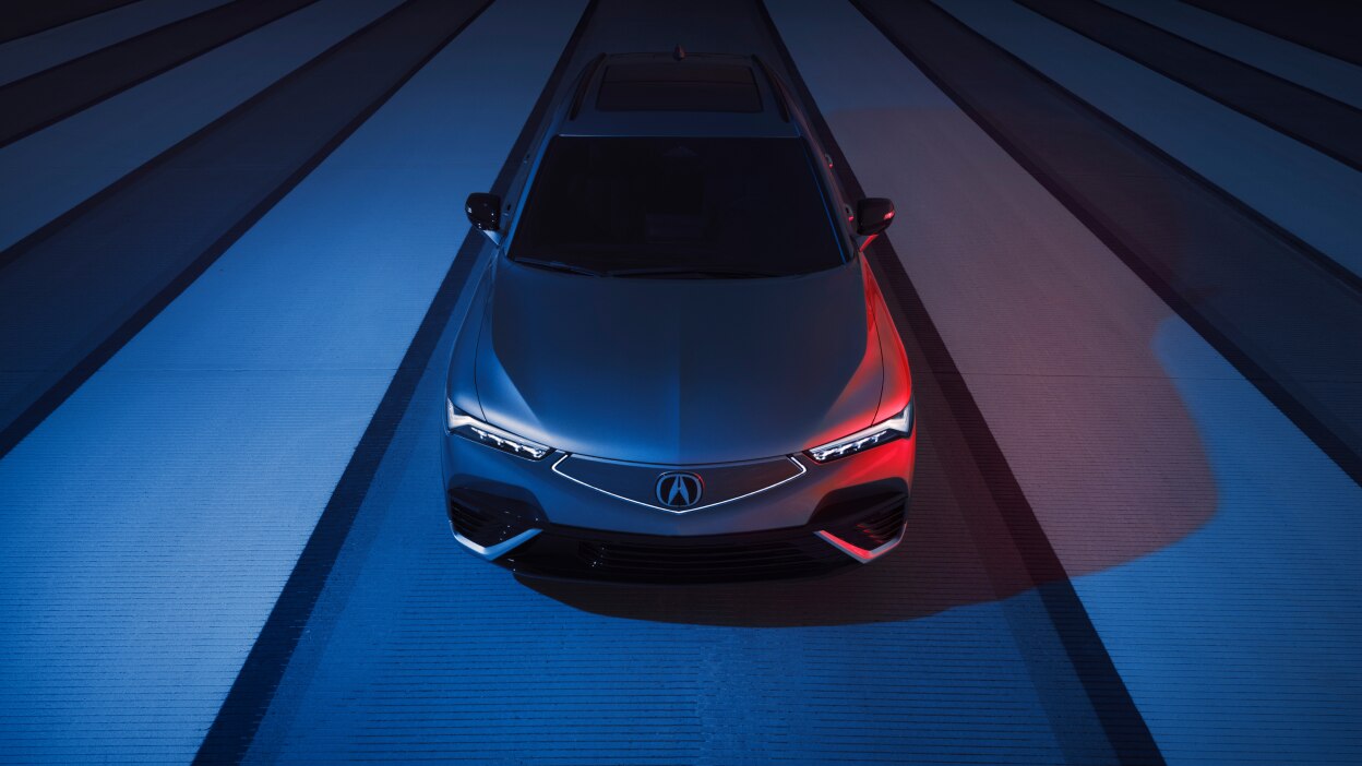 Plan de trois quarts avant en plongée d’un ZDX bleu sur une route de béton.