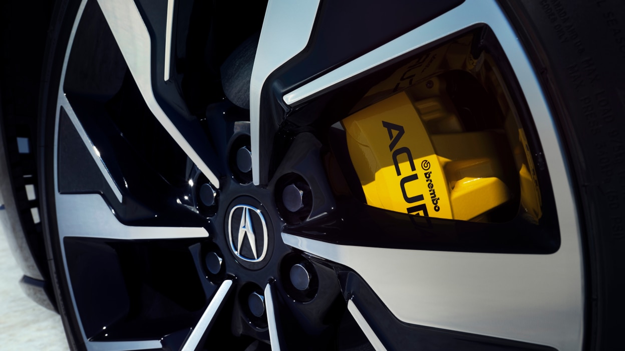 Macro closeup of wheel showcasing the yellow brake caliper.