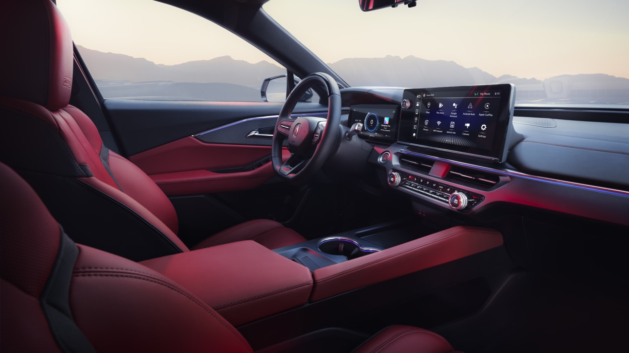Wide interior view of driver’s side of the cockpit, including leather-wrapped steering wheel, digital instrument cluster, and touchscreen.