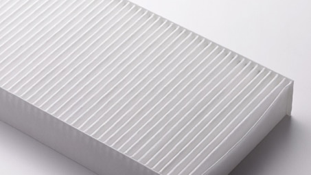 Zoomed in studio shot of an exposed cabin air filter. // Zoom en studio sur un filtre à air d'habitacle exposé